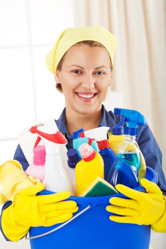 A cleaner smiling while wiping a surface